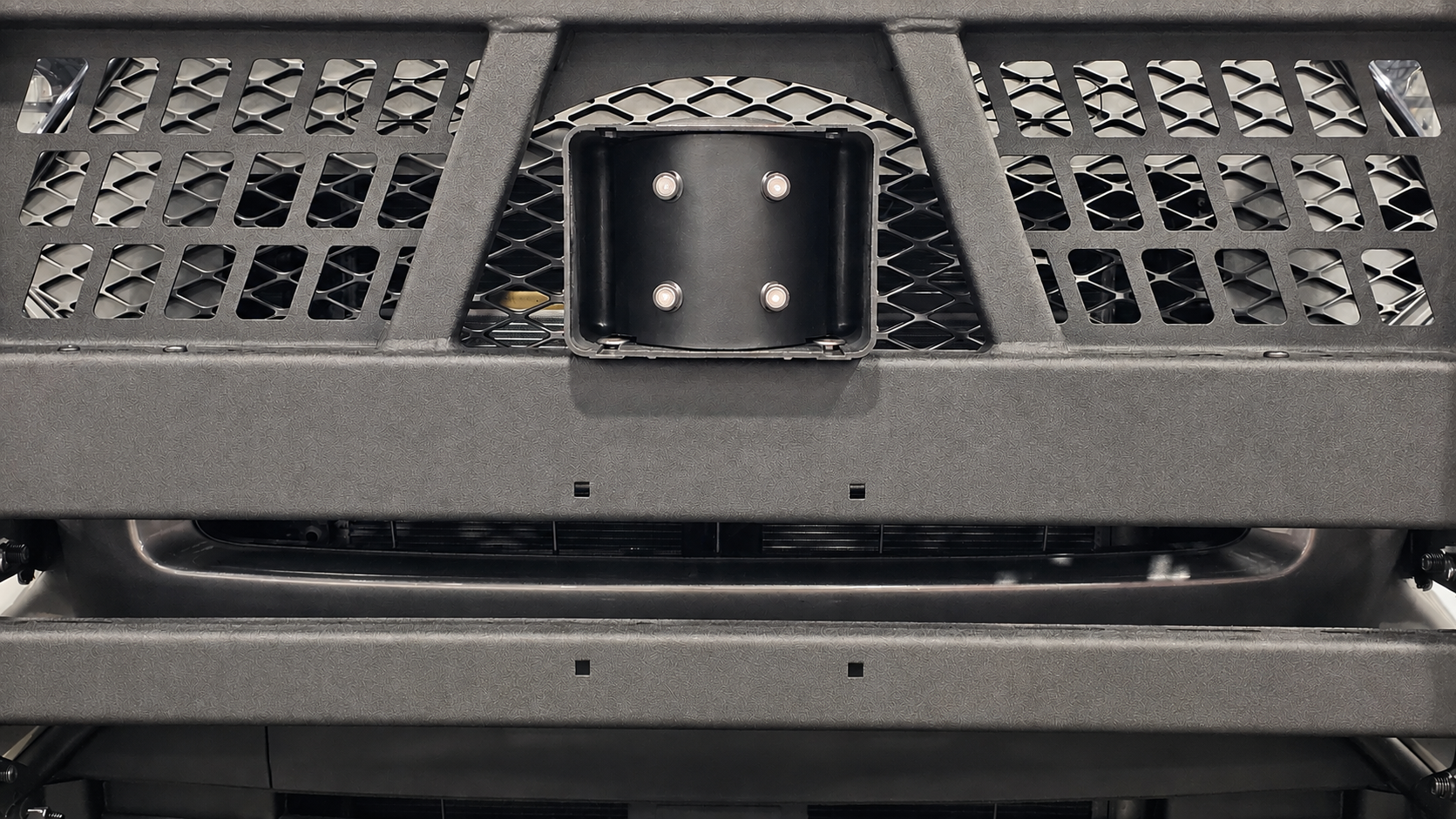 Emergency vehicle siren speaker mounted securely behind a vehicle grille