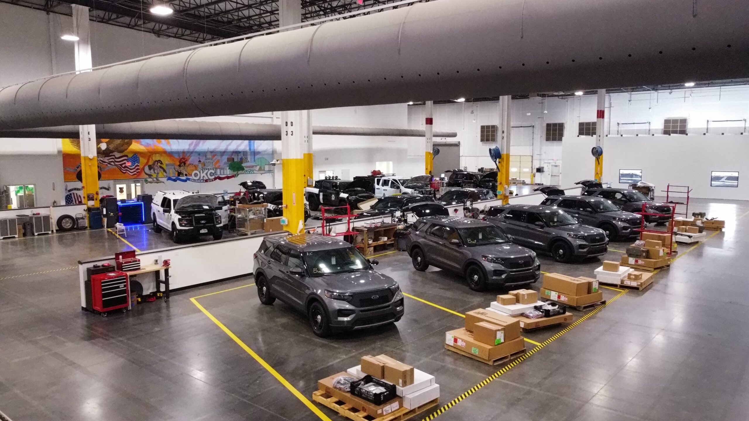 Commercial fleet vehicles inside the Metro Emergency Upfitters facility prepared for professional vehicle upfitting
