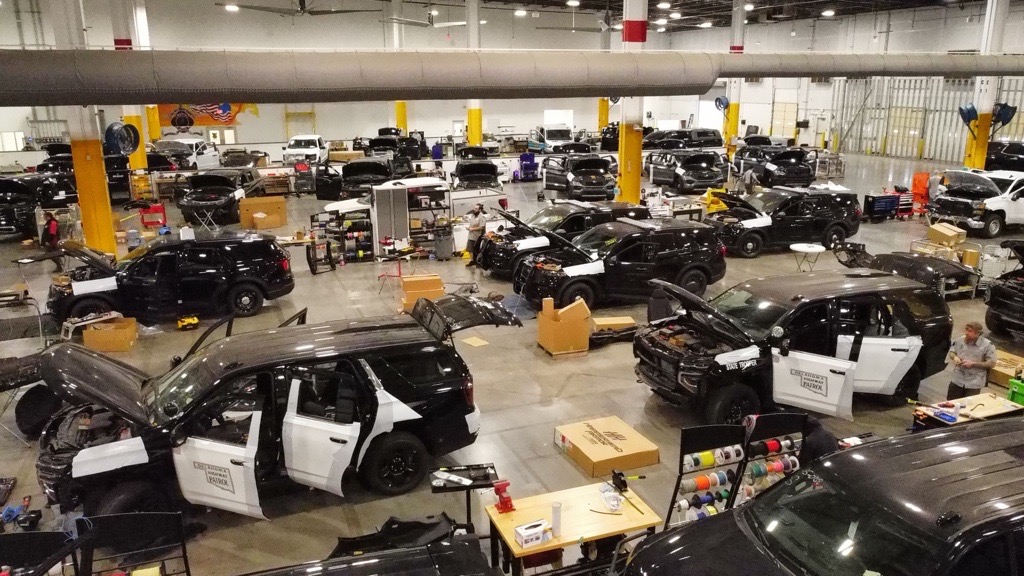 Multiple commercial fleet vehicles inside the Metro Emergency Upfitters shop