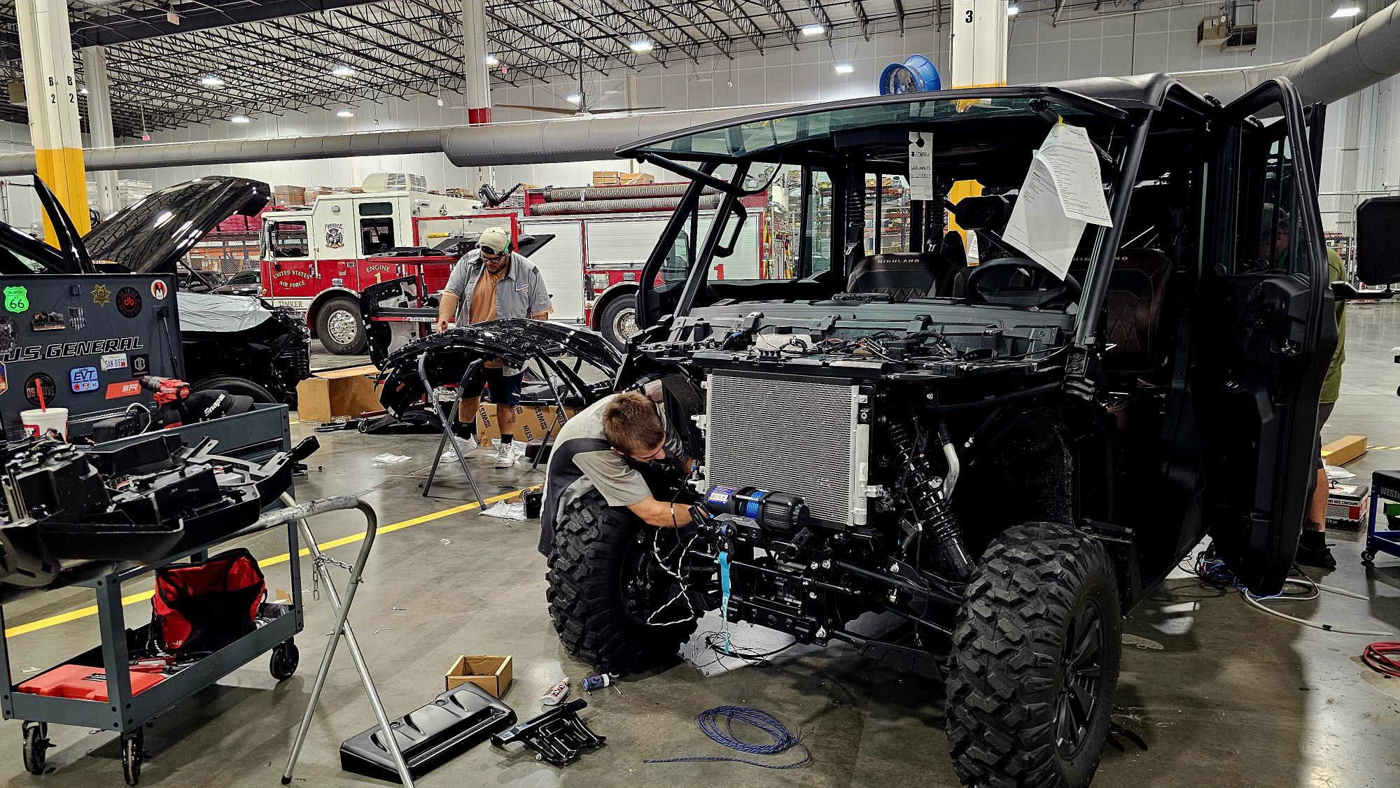 Technician installing wiring and emergency equipment inside a public safety vehicle